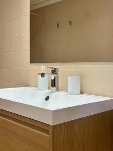 a bathroom with a white sink and a mirror at Cosy Flat Catarroja in Catarroja +11 photos