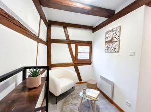 a living room with white walls and wooden beams at Duplex de Charme - Turckheim - Route des Vins in Turckheim