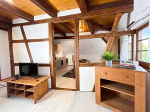 a living room with wooden beams and a tv and a desk at Duplex de Charme - Turckheim - Route des Vins in Turckheim