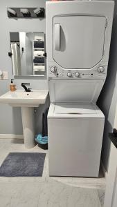 a white bathroom with a sink and a mirror at Heron Cottage on Cayuga Lake in Aurora