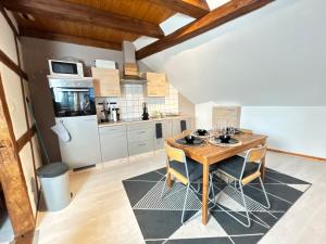 a kitchen with a wooden table and chairs at Duplex de Charme - Turckheim - Route des Vins in Turckheim