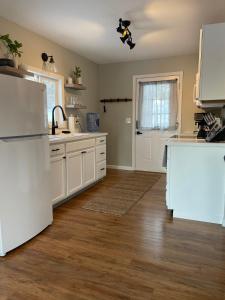 a kitchen with white appliances and a wooden floor at Heron Cottage on Cayuga Lake in Aurora