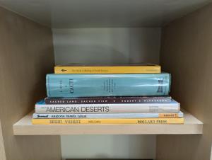a stack of books sitting on top of a shelf at Early Birds in Tucson