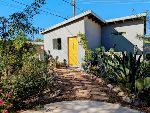 a house with a yellow door in a yard at Early Birds in Tucson