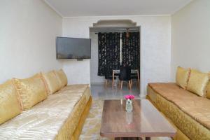 a living room with two couches and a table at Appartement Laaz in Midelt
