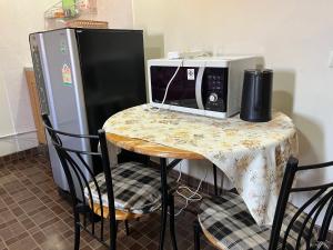 a kitchen with a table with a microwave and a refrigerator at Impact Arena C4 by Jintana in Ban Bang Phang