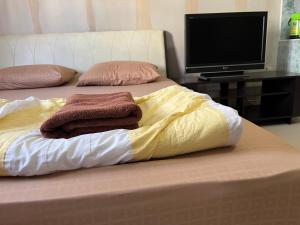 a bed with two pillows and a television on it at Impact Arena C4 by Jintana in Ban Bang Phang