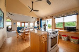 a kitchen with a stove and a dining room at Climate Change - Duck, Sea Tern, Oceanside, 280 Yds to Beach, Pool, Hot Tub, Pets OK in Duck +64 photos
