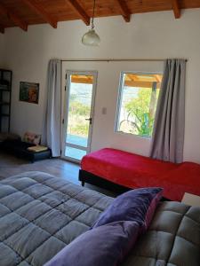 a bedroom with a large bed and a large window at Cielo in Tafí del Valle
