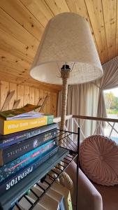 a stack of books on a table with a lamp at Czaple Resort in Stare Czaple