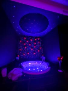 ein Zimmer mit einem großen Bett mit violetten Lichtern in der Unterkunft 50m2 Suite in Capurso