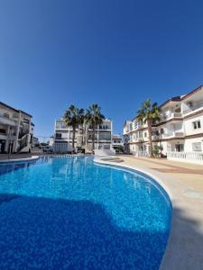 a large blue swimming pool in front of some buildings at Caballito del Mar apartment in Punta Prima
