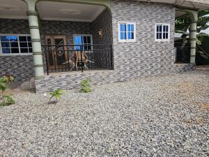 a house with a gate and a person on the porch at Gifted Estates in Accra