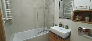 a white bathroom with a sink and a shower at APARTAMENT RELAX in Ełk +15 photos
