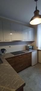 a kitchen with white cabinets and a counter top at APARTAMENT RELAX in Ełk