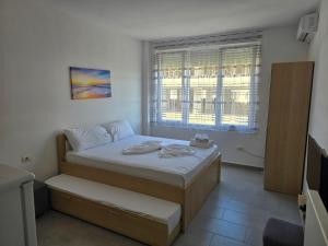 a small bedroom with a bed and a window at Roxhensi Apartments in Shëngjin