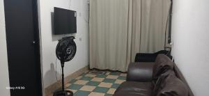 a living room with a couch and a flat screen tv at Casa no Centro de Piracicaba - SP in Piracicaba