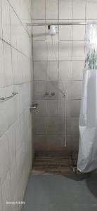 a shower in a white tiled bathroom at Casa no Centro de Piracicaba - SP in Piracicaba +13 photos