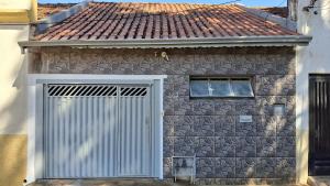 a stone house with a gate and a roof at Casa no Centro de Piracicaba - SP in Piracicaba