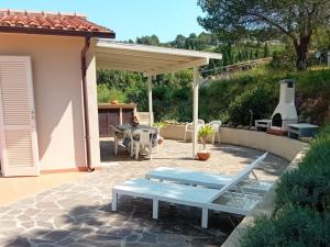 a patio with a blue bench and a table at Villa Ginanneschi - Le Pitte in Capoliveri