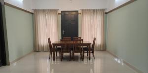 a dining room with a table and chairs and a door at The Rosetta Inn, Wayanad in Wayanad