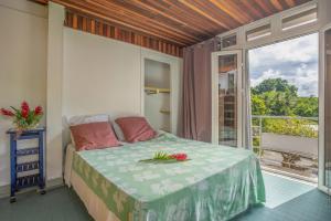 a bedroom with a bed with flowers on it at Villa Les Violettes in Morne-à-lʼEau