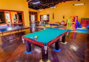 a room with a ping pong table and several play areas at Canto da Floresta Ecoresort in Amparo