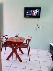 a room with a table and a tv on the wall at Aguapé quarto 3 in Barreirinhas