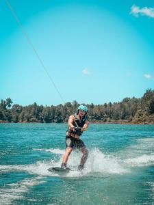 a man is water skiing on a body of water at La Jaus by Hope in Guatapé