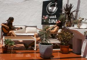 two people sitting on a couch playing guitar at Posada de la Luna in Granada