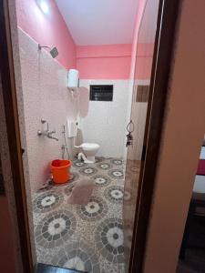a bathroom with a toilet and a pink ceiling at HostelVK Gokarna in Gokarna
