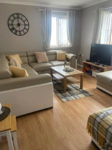 a living room with a couch and a table at Fraoch, Pets welcome in Port Bannatyne