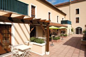 a patio with chairs and a wooden pergola at La Ferme Des Barmonts in Villejuif
