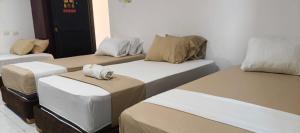 a group of four beds in a room at Hotel Girasol Inn Barranquilla in Barranquilla