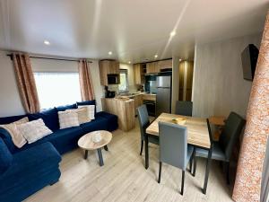 a living room with a blue couch and a table at Chalet Levy in Lauwersoog +29 photos