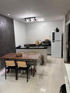 a kitchen with a table and chairs and a refrigerator at Casa em Dunas de Marapé -Jequia da praia in Jequia da Praia +5 photos