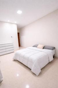 a white bedroom with a large bed in it at Casa em Dunas de Marapé -Jequia da praia in Jequia da Praia
