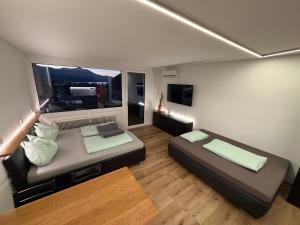 a small room with two beds and a large window at Wolfgangsee Seeblickplatzl in Strobl