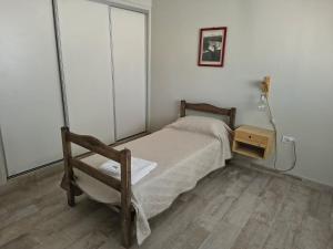 a small bedroom with a bed and a lamp at Lisboa in Chacabuco
