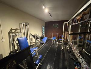 a gym with blue chairs and equipment in a room at Domus Hotel Veneza - Ipatinga in Ipatinga