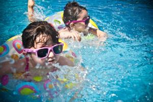 two children wearing sunglasses in a swimming pool at Die Landhofmühle in Windisch Minihof