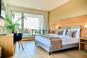 a bedroom with a large bed and a large window at Buchners Hotel & Restaurant in Niederwinkling +25 photos
