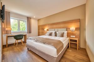 a hotel room with a large bed and a desk at Buchners Hotel & Restaurant in Niederwinkling