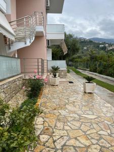 a stone walkway with potted plants in front of a building at Vila Melina in Himare
