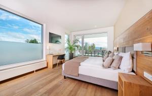 a bedroom with a large window with a bed and a desk at Buchners Hotel & Restaurant in Niederwinkling