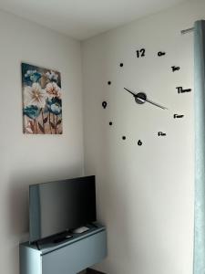 a room with a tv and a clock on the wall at Casa Rosetta in Tignale