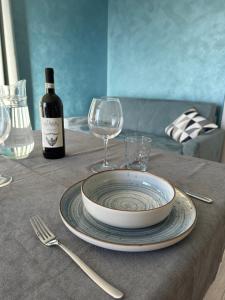 a table with a plate and a bottle of wine at Casa Rosetta in Tignale