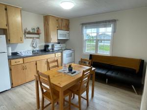a kitchen and dining room with a table and a couch at Buoy & Arrow Suites in Rocky Harbour