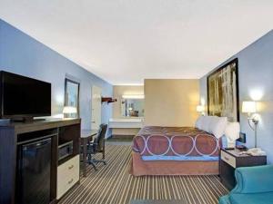 a hotel room with a bed and a flat screen tv at Downtown Inn & Studio Suites in Memphis