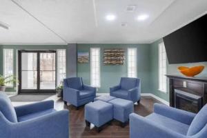 a living room with blue chairs and a fireplace at Downtown Inn & Studio Suites in Memphis